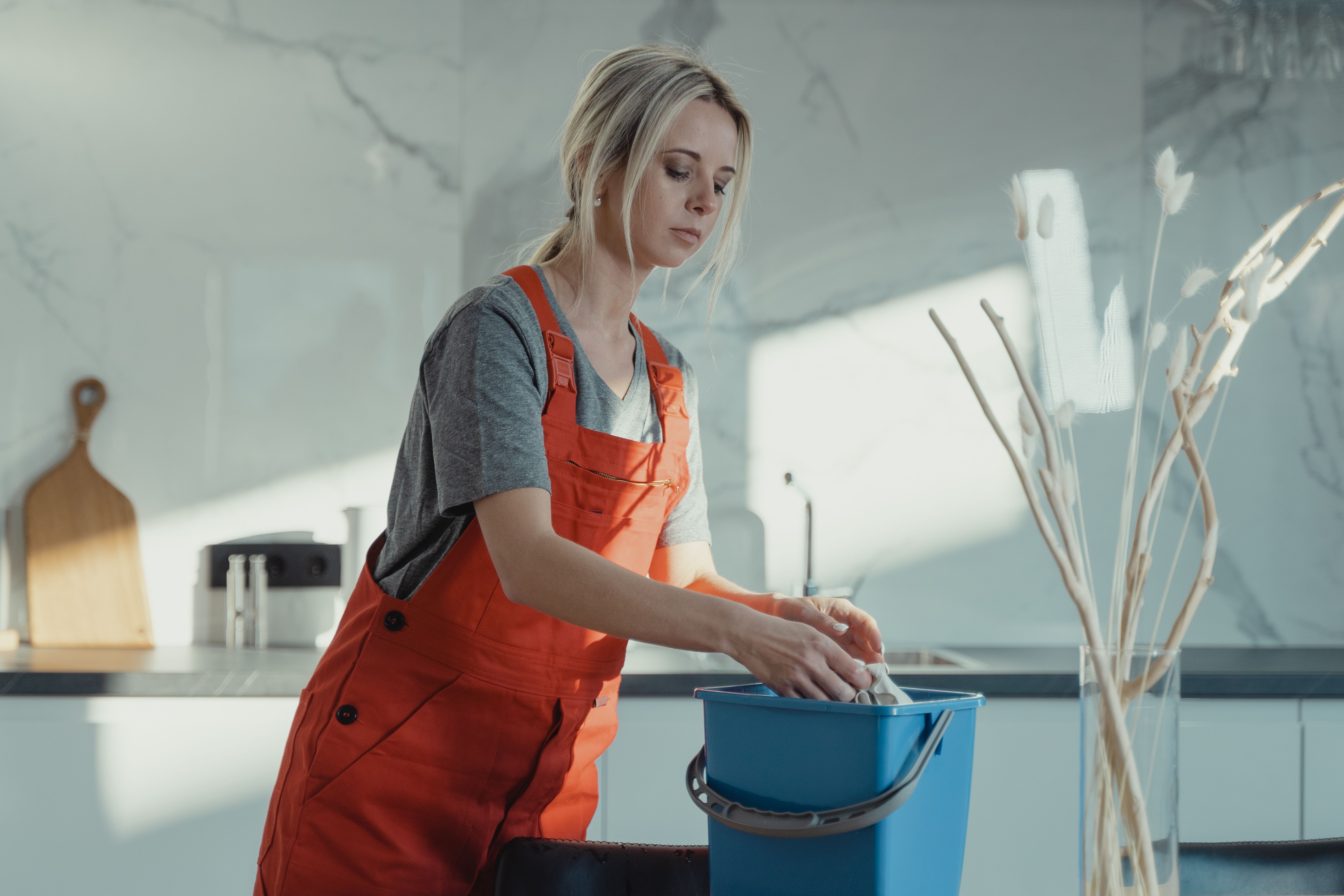 Professional housekeeper cleaning a residential kitchen